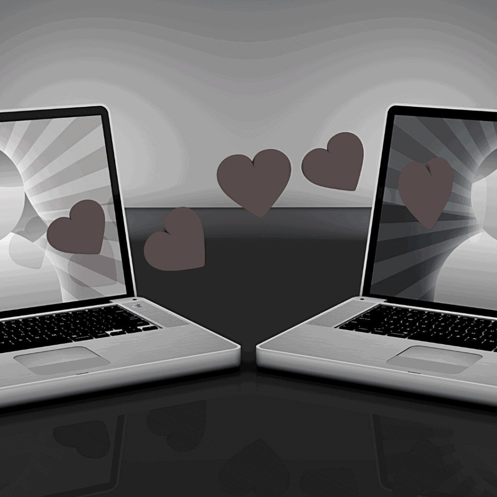 two laptops represents online dating of male and female with hearts between it