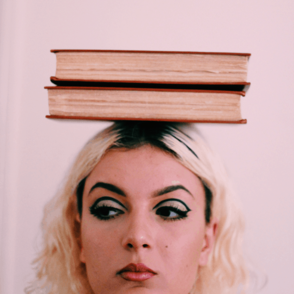 an image of a white blonde woman balancing 2 books on her head with a negative emotion showing on her face