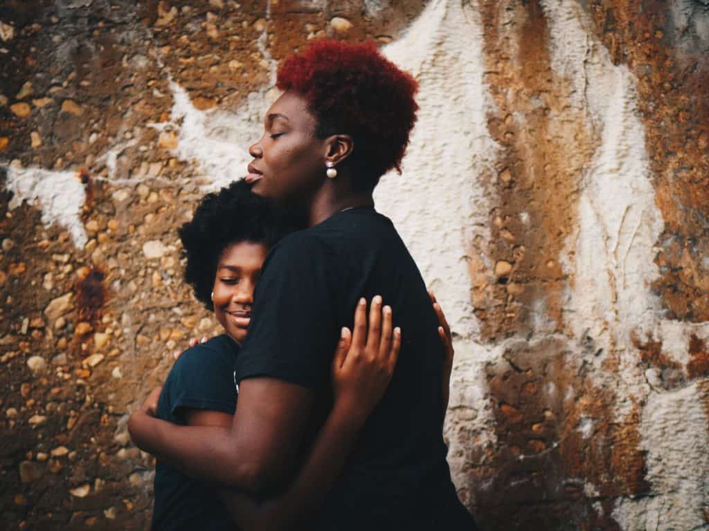 a photo of a black mother and child hugging each other