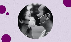 A featured sized imaged of a black and white image of a couple wearing facemask while facing each other just like kissing, and both eyes closed in a light purple background, and pink violet circles around it.