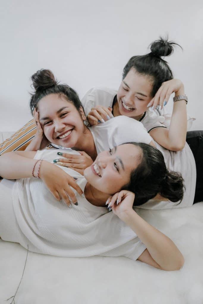 friends of three woman wearing white shirts, and laughing together