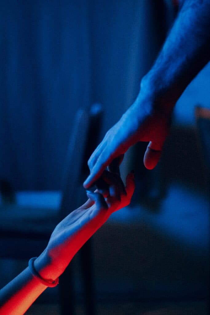 a photo of a hand of a man and a woman trying to hold unto each other but about to let go