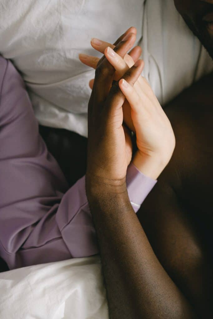 a photo of a white and black hand of couple holding each other