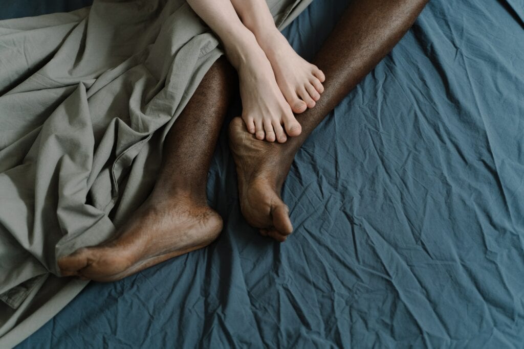 a photo of a woman and a man's legs on a bed