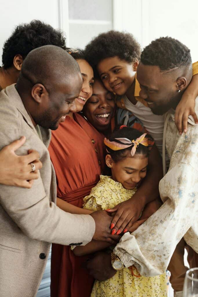 a photo of a black family hugging each other tight