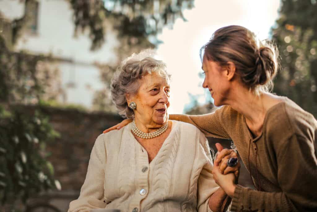 a photo of a middle aged woman talking to an old woman